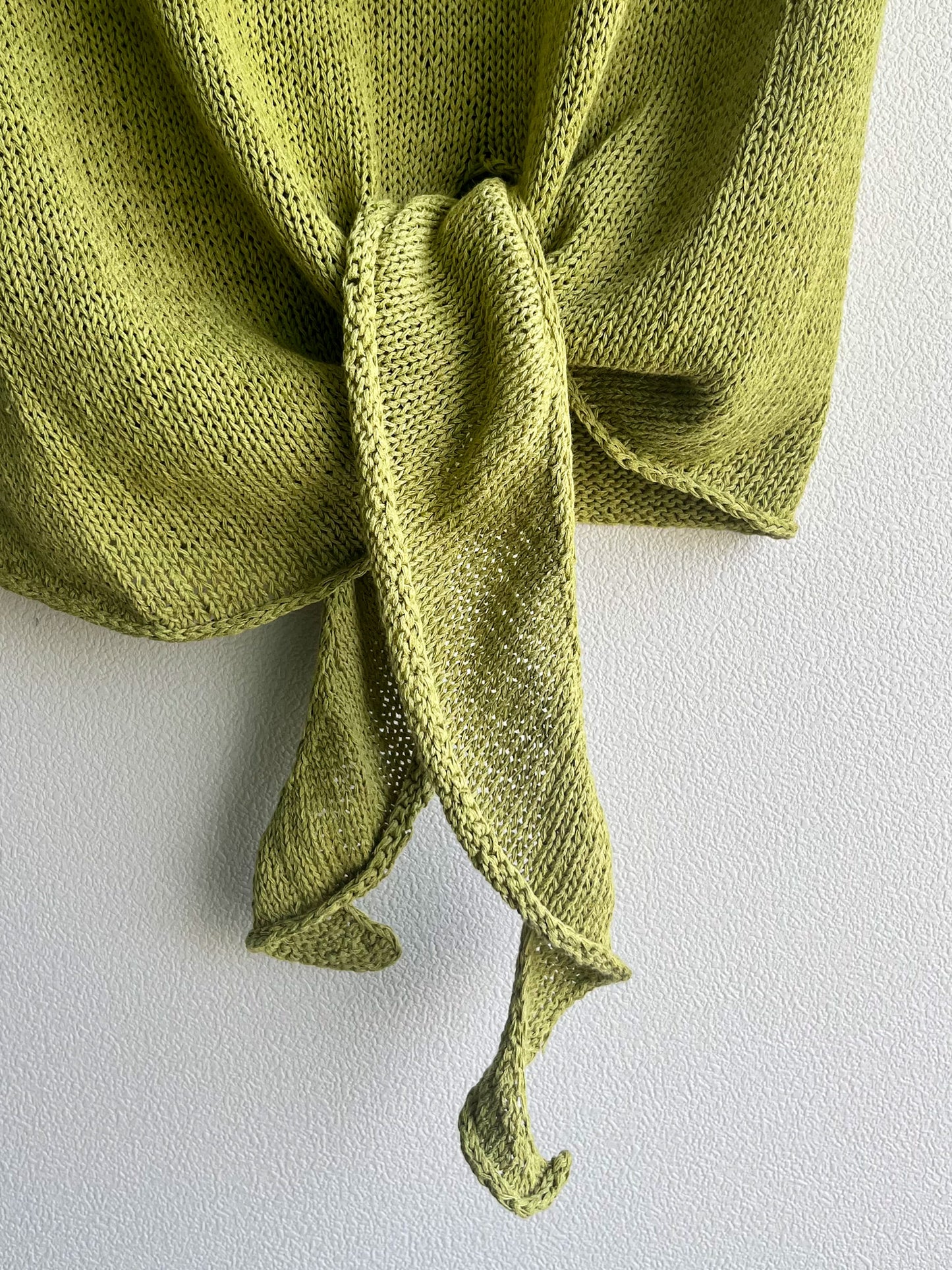 Close-up of Elio's asymmetric hem ties, knotted