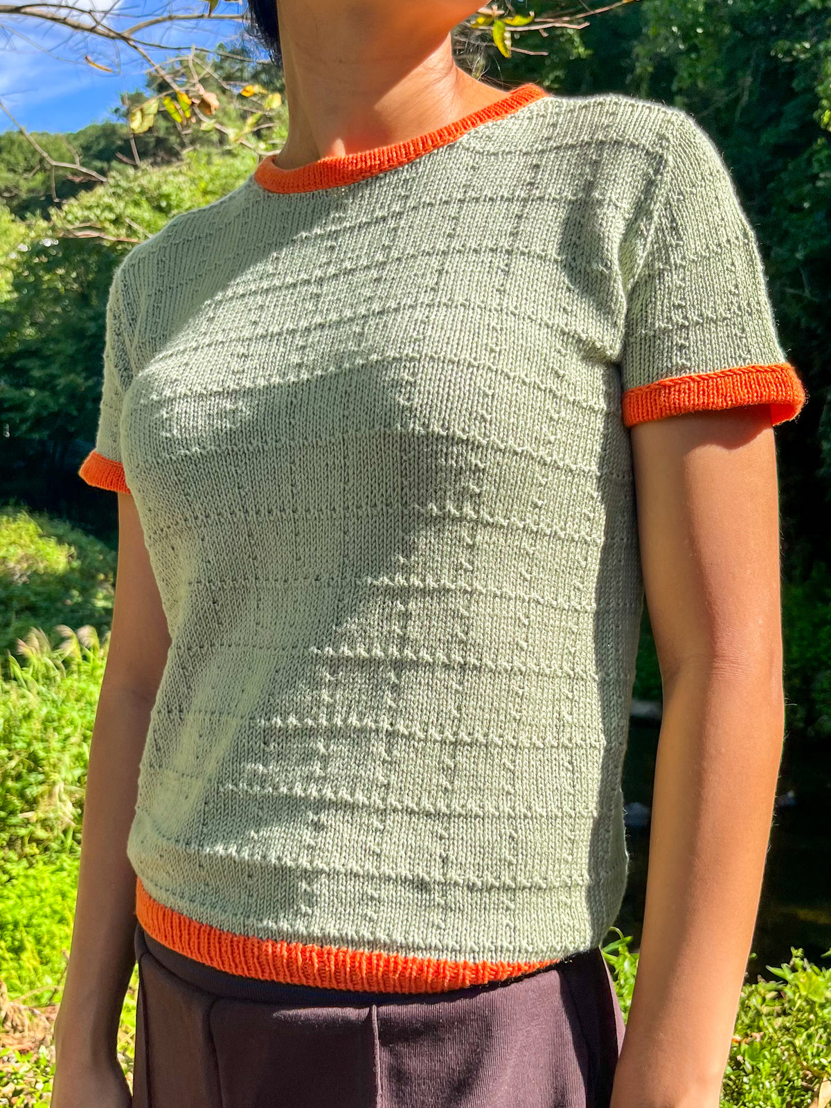 The Nancy Tee knit in Kit Couture Wool Cotton, sage with orange trim