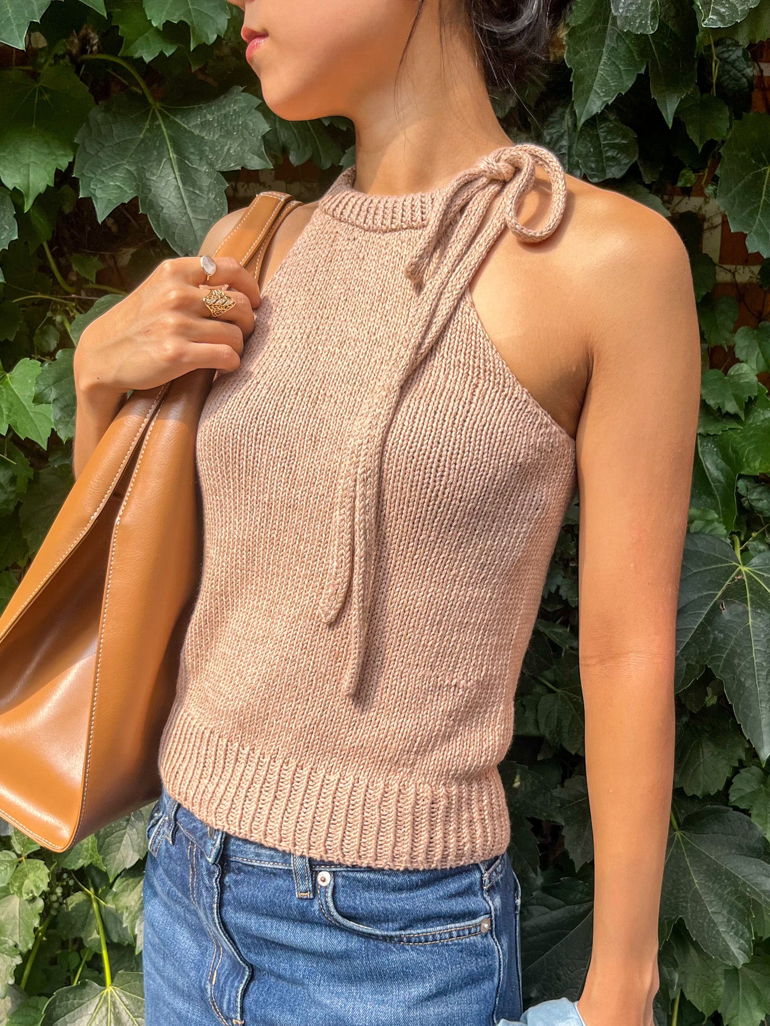 Odette Bow Halter Top worn in beige, side view with the I-cord bow tied at the left of the neckband